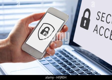 Cyber security symbol with icon of shield and lock on the screen of mobile phone and notebook computer Stock Photo