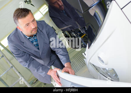 Mechanic with vehicle front panel Stock Photo