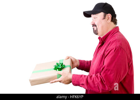 Side view of cheerful bearded mature man in red long sleeve shirt giving, delivering or receiving a gift Stock Photo