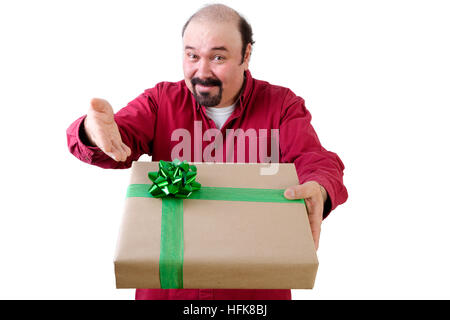 Smiling balding middle-aged man handing over a large gift box with decorative green bow gesturing with his hand to show - Its Yours - upper body isola Stock Photo