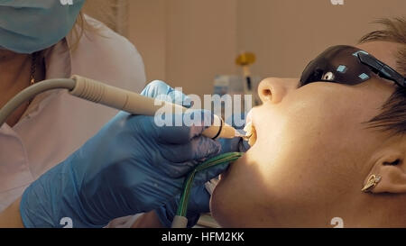 Woman ultrasonic tooth plaque odontolith removing Stock Photo