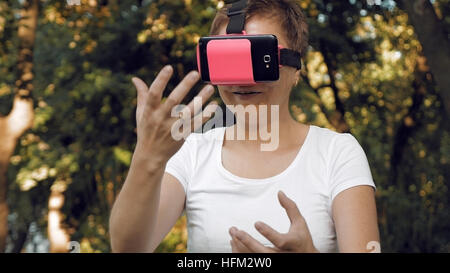 Woman explores virtual reality using VR glasses Stock Photo