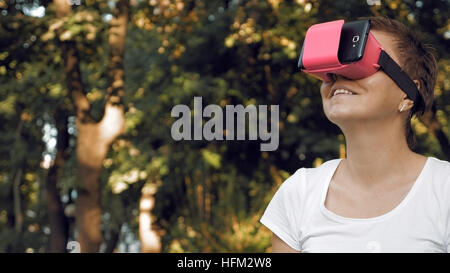 Woman explores virtual reality using VR glasses Stock Photo