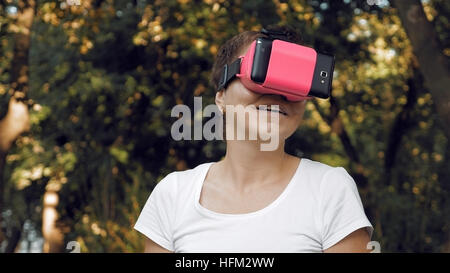 Woman explores virtual reality using VR glasses Stock Photo