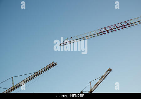 Three construction cranes by a blue sky Stock Photo