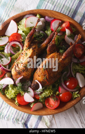 grilled quail and salad of fresh vegetables close-up on a plate. vertical top view Stock Photo