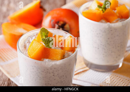 dessert with chia seeds and persimmon close up in a glass on the table. Horizontal