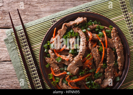 Asian Food: Bulgogi beef slices fried with sesame and carrot close-up on a plate. horizontal top view Stock Photo