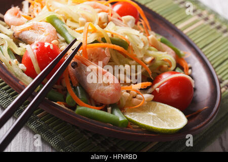 Thai green papaya salad som tam with shrimp on a plate. macro, horizontal Stock Photo