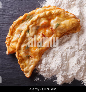 Italian food: pizza calzone and white flour close-up on the table. top view Stock Photo