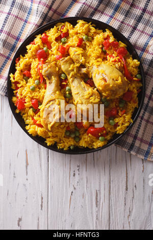 Spanish paella with chicken and vegetables on a plate. vertical top view Stock Photo