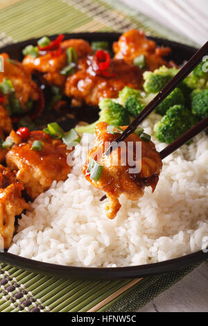 Asian food: General Tso's chicken with rice for dinner. vertical, macro Stock Photo