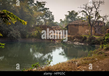 Scenic village pond with ducks swimming surrounded with mud houses. Rural Indian village in Bankura, West Bengal. Stock Photo