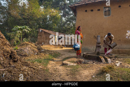 Tribal women draws water from a deep tube well at a rural Indian village in Bankura, West Bengal. Stock Photo