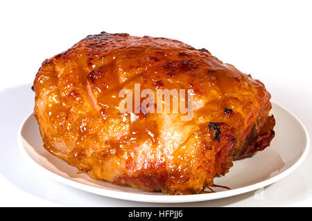 Studio shot baked gammon covered with sweet glaze on white plate Stock Photo