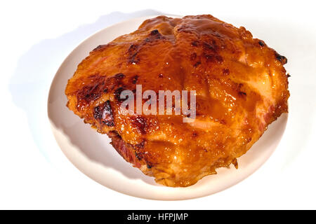 Studio shot above view of baked gammon covered with sweet glaze on white plate Stock Photo