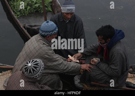 India. 31st Dec, 2016. Kashmiri boatmen exchange currency notes after selling their produce at the floating vegetable market in the interiors of famed Dal Lake in Srinagar, the summer capital of Indian controlled Kashmir on December 31, 2016. Vegetables sold in the floating market are supplied to many parts of Srinagar across the Kashmir. Selling vegetables has been the major source of income for the inhabitants of interiors of Dal Lake. © Faisal Khan/Pacific Press/Alamy Live News Stock Photo