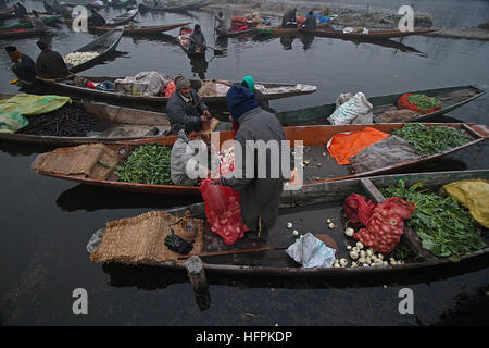 India. 31st Dec, 2016. A Kashmiri boatman (c) attends a customer at the floating vegetable market in the interiors of famed Dal Lake in Srinagar, the summer capital of Indian controlled Kashmir on December 31, 2016. Vegetables sold in the floating market are supplied to many parts of Srinagar across the Kashmir. Selling vegetables has been the major source of income for the inhabitants of interiors of Dal Lake. © Faisal Khan/Pacific Press/Alamy Live News Stock Photo