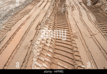 Bulldozer tracks on a surface of brown and gray sand Stock Photo