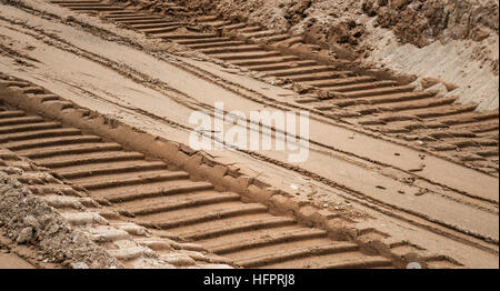 Bulldozer tracks on a surface of brown and gray sand Stock Photo