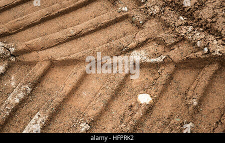 Bulldozer tracks on a surface of brown and gray sand Stock Photo