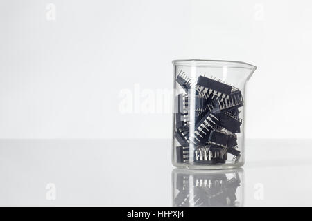 Beaker holding computer chips inside shot in the studio on white background Stock Photo