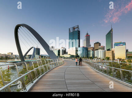 Twilight view along the Elizabeth Quay pedestrian bridge to the city skyline beyond, Perth, Western Australia, Australia Stock Photo