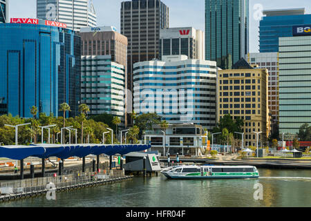 A Swan River ferry arriving at Elizabeth Quay ferry terminal with the city skyline beyond.  Perth, Western Australia, Australia Stock Photo