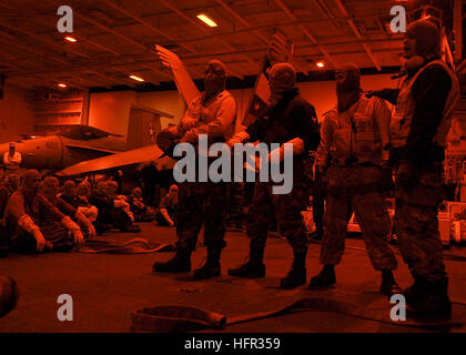 060304-N-9898L-025 Pacific Ocean (March 4, 2006) Ð Sailors gather in hangar bay two for a lecture on fire hose team responsibilities during a general quarters (GQ) drill aboard the Nimitz-class aircraft carrier USS Abraham Lincoln (CVN 72). Lincoln and embarked Carrier Air Wing Two (CVW-2) are deploying on a six-month deployment in support of Maritime Security Operations (MSO) and the global war on terrorism.  U.S. Navy photo by Photographer's Mate Airman Geoffrey Lewis (RELEASED) US Navy 060304-N-9898L-025 Sailors gather in hangar bay two for a lecture on fire hose team responsibilities durin Stock Photo