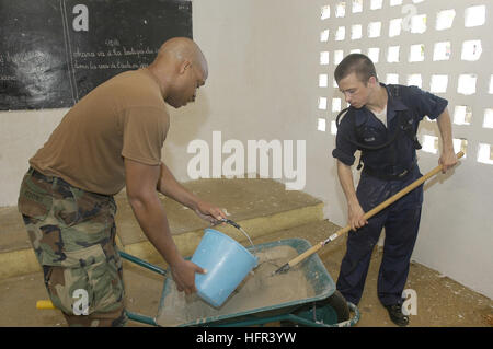 060323-N-2420K-022 Pointe Noire, Republic of Congo (March 23, 2006) - Naval Mobile Construction Battalion Seven (NMCB-7), Petty Officer 1st Class Jamal Redding, left, and Torpedoman's Mate Seaman Zachary Albasin, assigned to the submarine tender USS Emory S. Land (AS 39), mix cement to be used to resurface the floor of the Jean Felix Tchicaya Primary School during a Community Relations (COMREL) project. Land Sailors are currently conducting training exercises and COMREL projects with various Gulf of Guinea countries. U.S. Navy photo by Photographer's Mate 2nd Class Jonathan Kulp (RELEASED) US  Stock Photo