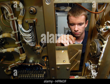 Electronics Technician performs voltage check on power circuit card in Air Navigation Equipment room aboard USS Abraham Lincoln during deployment supporting Operations Iraqi Freedom, Enduring Freedom, and maritime security. Stock Photo