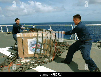 060509-N-3714J-054 Pacific Ocean (May 9, 2006) - Storekeeper 3rd Class Christian Sabandal of Los Angeles, Calif., and Storekeeper 3rd Class Rommer Gonzales of San Diego, Calif., prepare boxes to be air lifted in support of Project Handclasp from Military Sealift Command (MSC) hospital ship USNS Mercy (T-AH 19). Mercy is on a five-month deployment during which it will visit areas of South Asia, Southeast Asia, and the Pacific Islands where its crew and several health and civic-related organizations will work together to aid in humanitarian assistance and civic efforts. Project Handclasp accepts Stock Photo