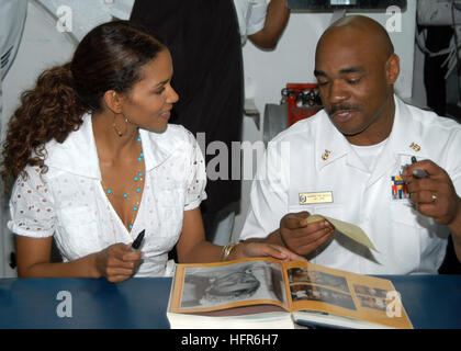 060524-N-7365V-114  New York Harbor (May 24, 2006) Ð Academy Award winning Actress Halle Berry signs a copy of the most recent shipÕs cruise book, belonging to Master Chief Quarter Master Leon Walker from Chicago, Illinois.  Berry who plays ÒStormÓ in the 20th Century Fox upcoming action, sci-fi, ÒX-Men: The Last Stand,Ó visited with Sailors and embarked Marines during the opening day of Fleet Week New York 2006.  The crew was also given a special sneak preview of the film before its worldwide release date of May 26, 2006. Fleet Week has been sponsored by New York City since 1984 in celebratio Stock Photo
