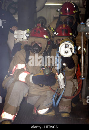 061019-N-0730W-013 Atlantic Ocean (Oct. 19, 2006) - Members of the at-sea fire party, Damage Controlman 2nd Class Darren Falcon, Damage Controlman 2nd Class Jeremiah McCullough, and Damage Controlman 3rd Class Dennis Cherry train to fight a fire in the auxiliary machinery room aboard the amphibious assault ship USS Wasp (LHD 1). Wasp conducts regular damage control training underway and in port to keep Sailors prepared in the event of an actual casualty. U.S. Navy photo by Mass Communication Specialist 3rd Class Sarah West (RELEASED) US Navy 061019-N-0730W-013 Members of the at-sea fire party, Stock Photo