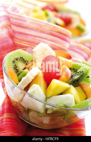 Fruit salad: kiwis, bananas, apples, peaches, mangoes, grapes and maraschino cherries Stock Photo