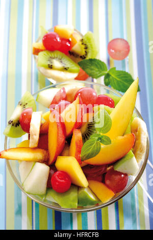 Fruit salad: kiwis, bananas, apples, peaches, mangoes, grapes and maraschino cherries Stock Photo