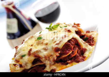 Lasagna, red wine in background Stock Photo