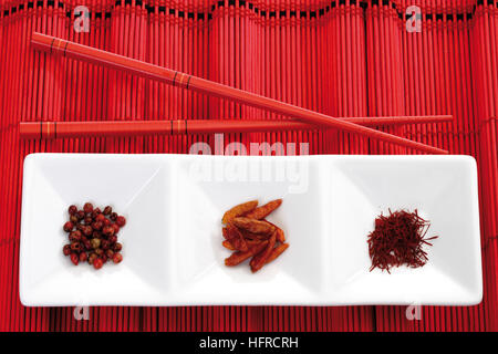 Bowls containing dried chili peppers, pink pepper and saffron threads Stock Photo