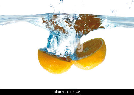 Two orange halves dunked into water Stock Photo