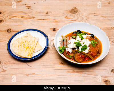 Fasolakia or Greek Bean Stew served with Feta cheese black olives flat leaf parsley and buttered pitta bread Stock Photo