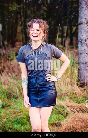 Girl posing infront of forest and laughing Stock Photo