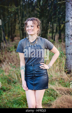 Girl posing infront of forest and laughing Stock Photo