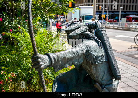 Ottawa, Canada - September 2, 2016: Metal sculpture of native man in traditional attire kneeling with quills. Stock Photo