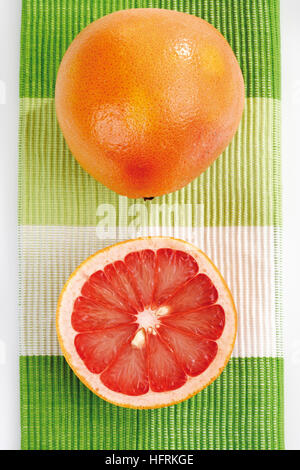 Ruby Red Grapefruits (Citrus x paradisi), whole and halved Stock Photo