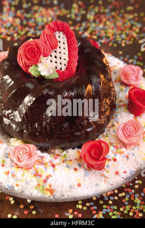 Chocolate-glazed bundt cake decorated with frosting heart Stock Photo