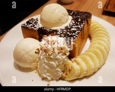 Decorated Honey and chocolate lava on Toast with vanilla ice cream and banana and whipped cream in restaurant thailand Stock Photo