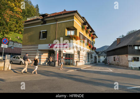 Unrecognized people walk along supermarket Mercator on the road around Lake Bled shore, Slovenia. Stock Photo