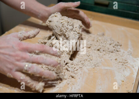 Hands of woman kneading cake dough on a cutting board for a gingerbread Stock Photo
