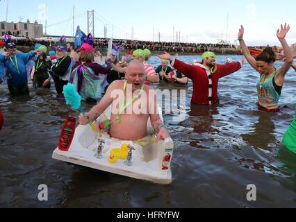 Swimmers take part in the Loony Dook New Year's Day dip in the Firth of Forth at South Queensferry, as part of Edinburgh's Hogmanay celebrations. Stock Photo