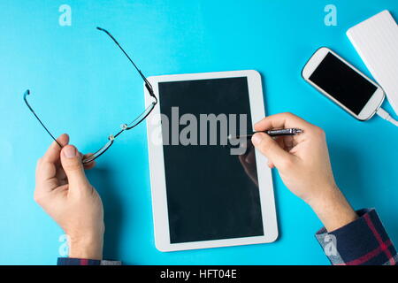 Man using a white tablet device at the office Stock Photo